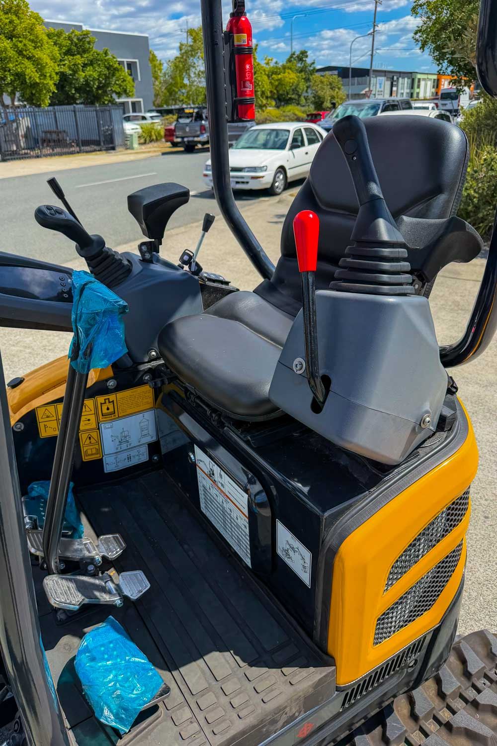 Close-up of the excavator operator seat and joystick handles with auxiliary hydraulic controls for the grab